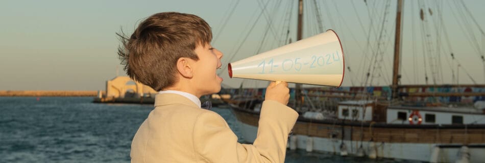 niño de comunion sosteniendo un megáfono
