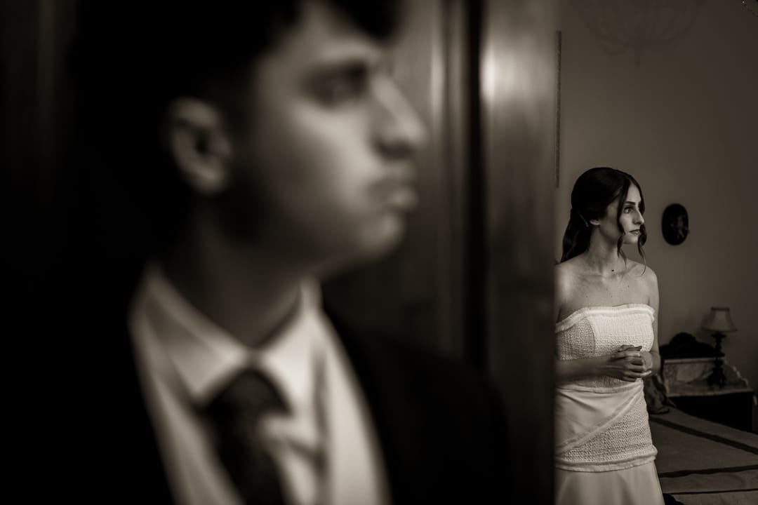 Novia ajustándose el vestido con el novio cerca