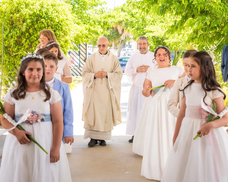 Niño de comunión sentado en el banco de la iglesia