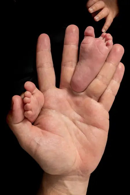 Detalle de manos sobre la barriga en una sesión de maternidad