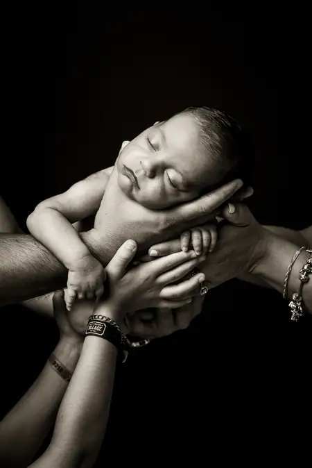 Retrato de maternidad de perfil con vestido y manos sobre la barriga