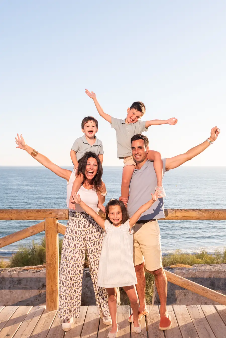 Hermanos riendo juntos sentados en la arena