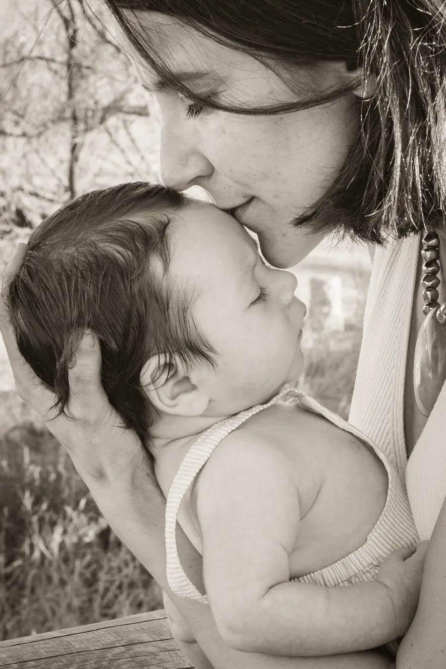 Padre levantando a su hijo al cielo frente al mar