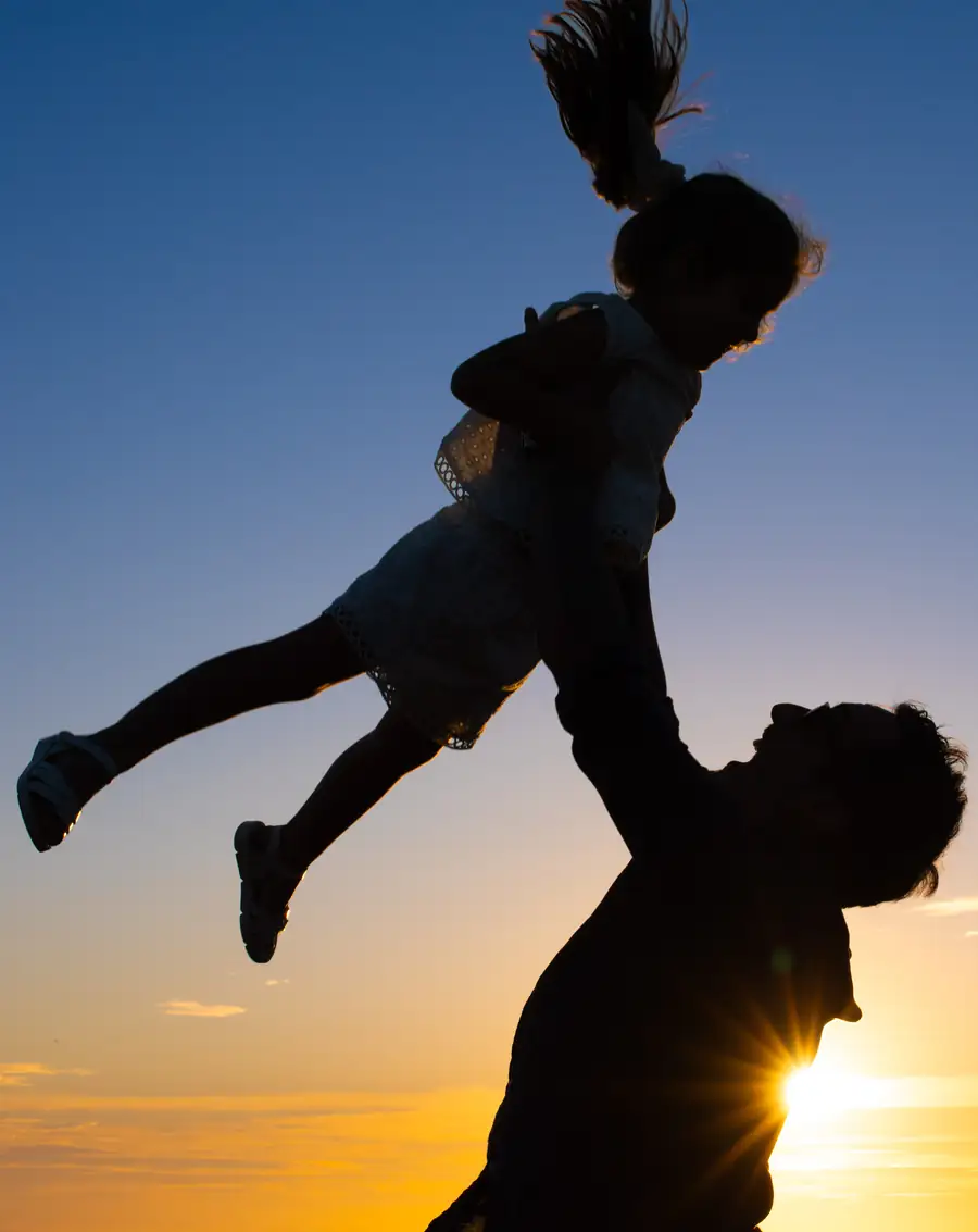 Familia jugando entre dunas iluminadas por el atardecer