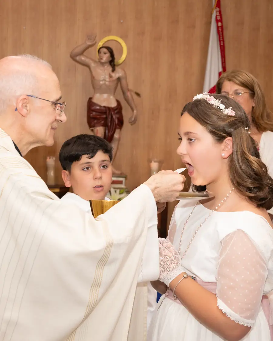 Niño acercándose al altar con su vela de comunión