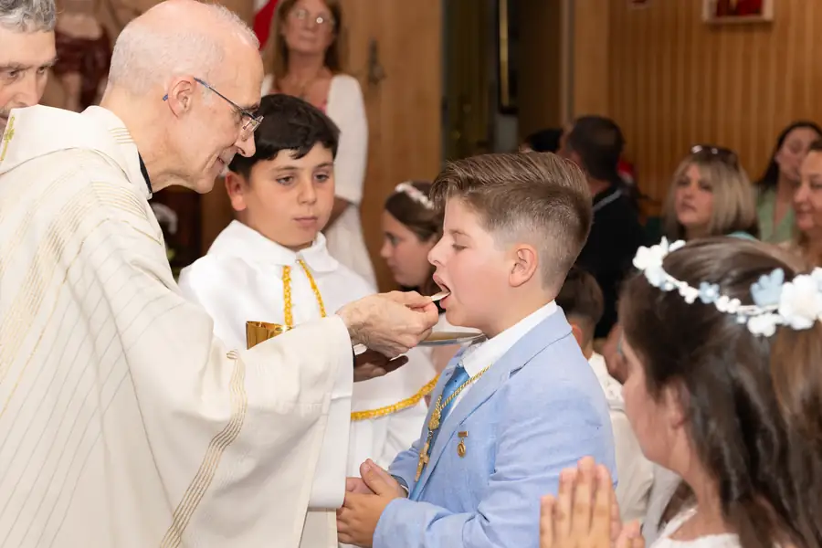 Momento de la eucaristía con el sacerdote y el niño en el altar