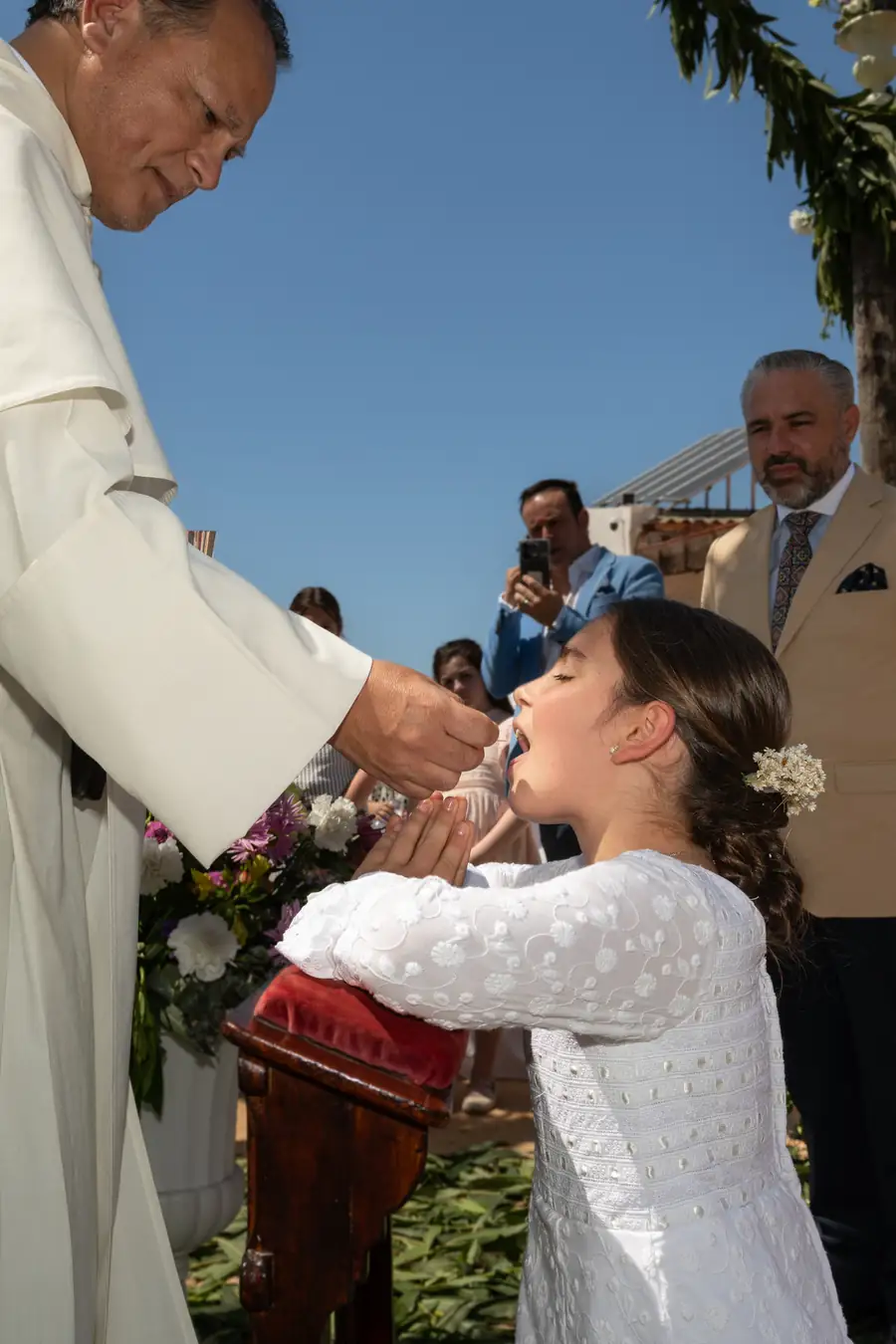 Niños con velas rodeando el altar en la comunión