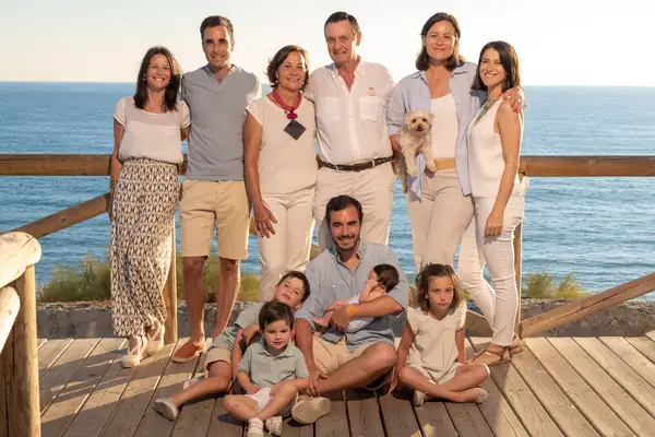 Padres e hijos jugando juntos al aire libre durante una sesión de fotos familiar.