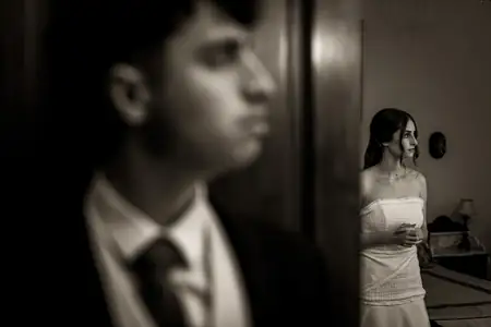 Novia ajustándose el vestido con el novio cerca