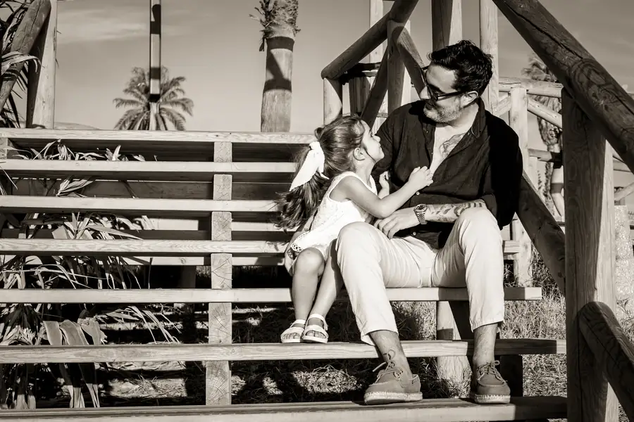 Retrato en contraluz de familia abrazada al atardecer