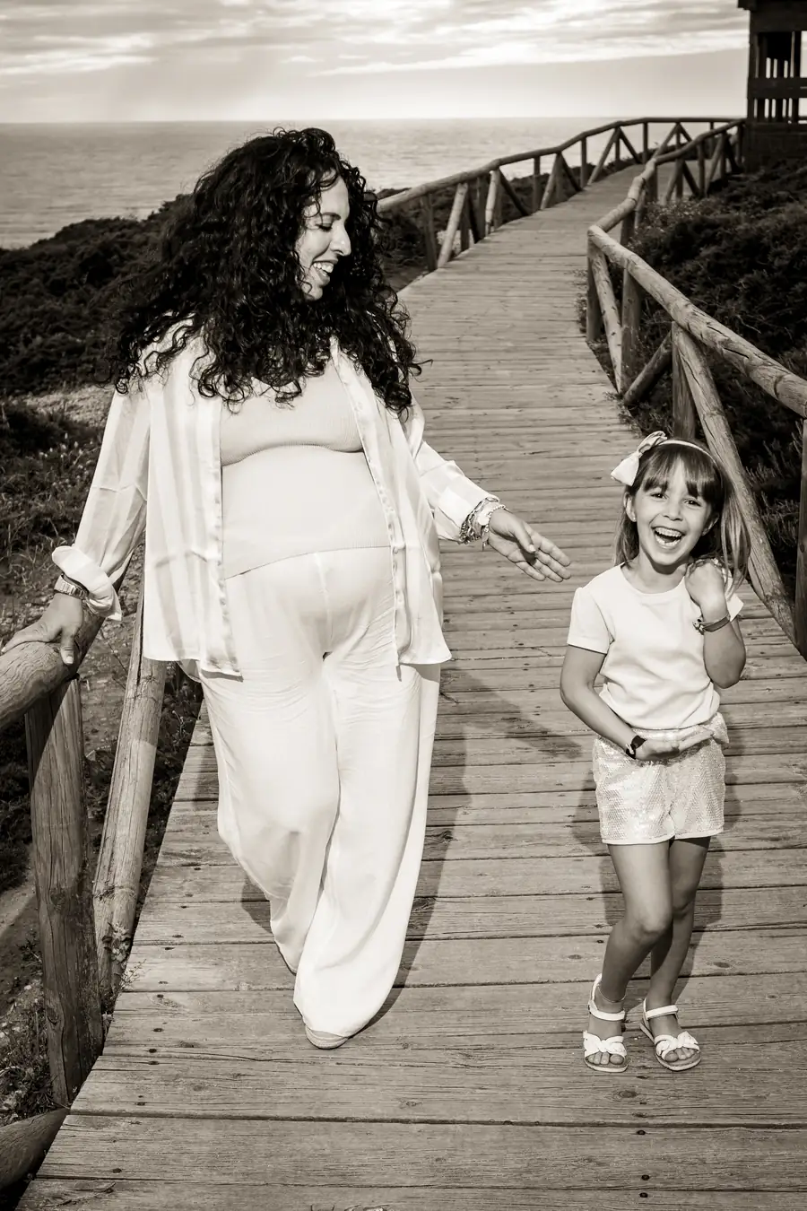 Niño sonriendo mientras juega con la arena en la playa