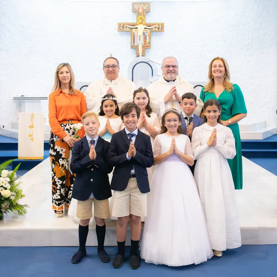 Detalle de manos rezando con rosario durante la comunión