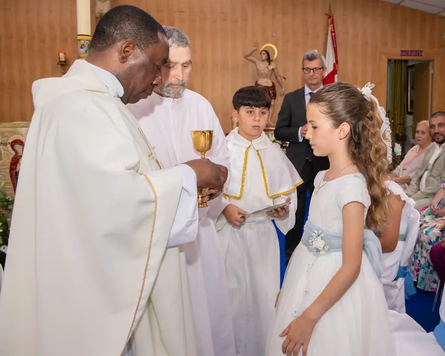 Niños de comunión rezando en los bancos de la iglesia