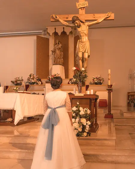 Niño de comunión rezando en una iglesia de Cádiz